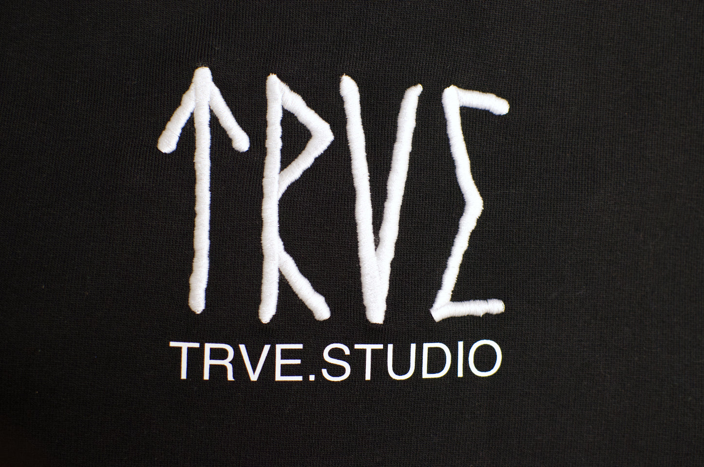 White embroidered runes "TRVE" + TRVE.STUDIO printed underneath 